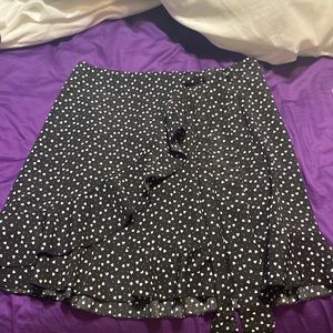 Black skirt with white hearts, tie in front, ruffles in front.